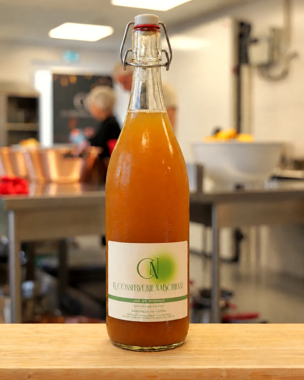 Bouteille de jus de pommes de La Conserverie Naborienne dans l'atelier