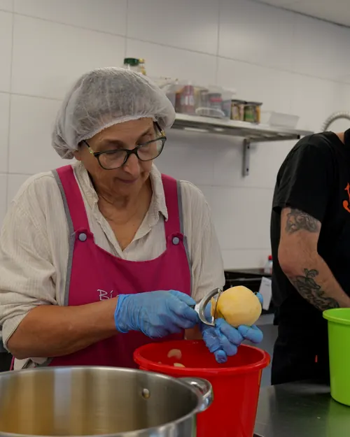 Une salariée épluche des pommes à l'atelier